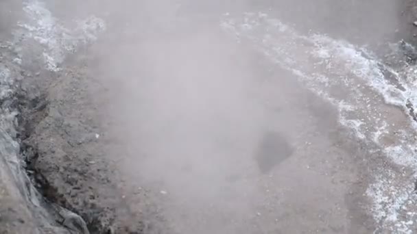 La vapeur provient de la couverture d'égout sanitaire dans la neige sur le bord de la route. Vue de dessus. Gros plan . — Video