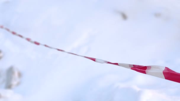 Let op tape op de weg in de stad close-up rood en wit. Winterdag en sneeuwlaag — Stockvideo