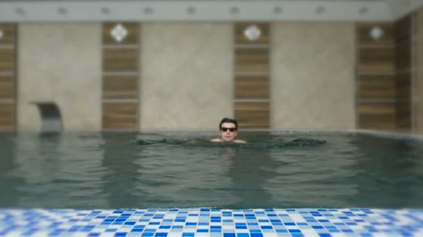 Hombre nada en la piscina en gafas de sol . — Vídeos de Stock