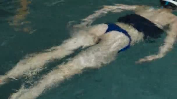 Hombre y mujer nadan juntos en la piscina . — Vídeos de Stock