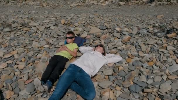 Mãe e filho descansando sobre as rochas . — Vídeo de Stock