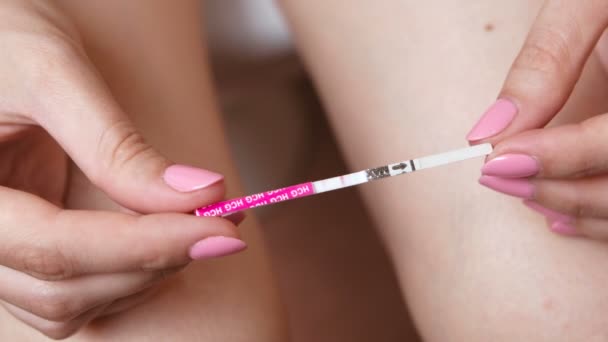 Žena dělá těhotenský test. Čekání na výsledek, při pohledu na testovací proužek. Detail ruce a nohy. — Stock video