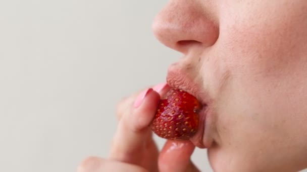 Kobieta zjada truskawki. W ustach zbliżenie. Widok z boku. — Wideo stockowe
