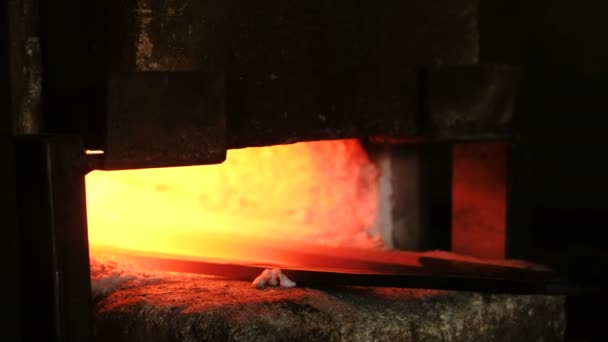 Haciendo la espada de metal en la fragua. Calentamiento de palanquillas metálicas en el horno . — Vídeos de Stock