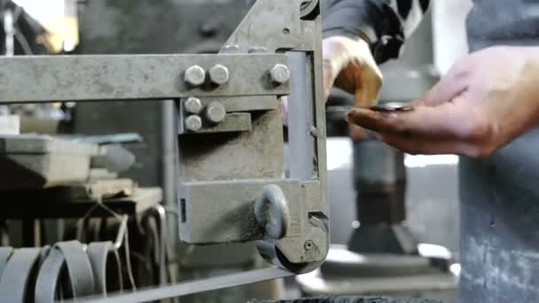 Broyage de billettes de couteau en métal sur une rectifieuse à courroie. Gros plan des mains d'un homme . — Video