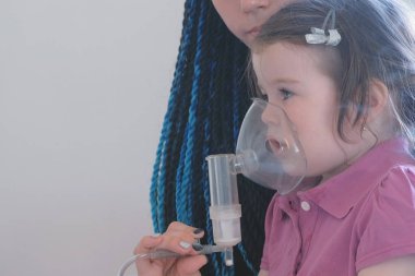 Kız annesiyle inhaler maskesi teneffüs edilmesi. Nebulizatör ve astım tedavisi için kullanın.