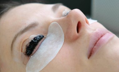 Güzellik bakımı. Closeup womans kirpik boya ile karşı karşıya. Botox ve kirpik laminasyon. Yan görünüm.