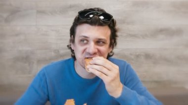 Adam bir hamburger ve aynı anda kafede oturan shawarma yeme.