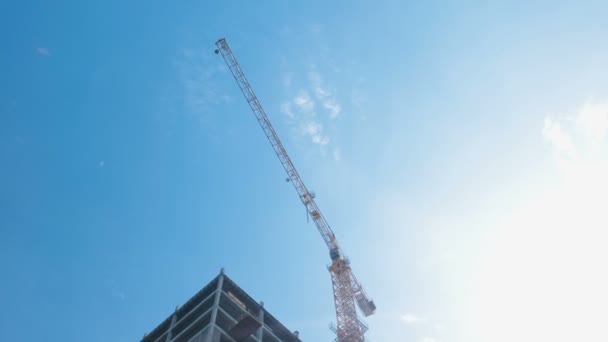 Meerdere verdiepingen onder Bouw gebouw en bouw kraan op de achtergrond van de heldere hemel. — Stockvideo