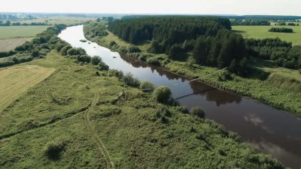 Volando sobre el pueblo, campos, ríos y bosques. Hermosa vista de pájaro en puente colgante sobre el río . — Vídeos de Stock