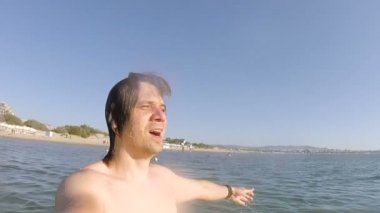 Bu mutlu bir adamın yüzme ve denizde dalış selfie.