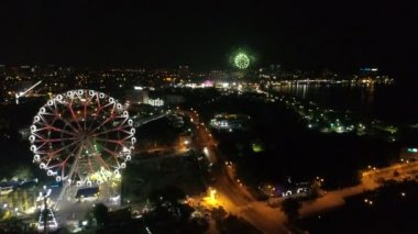 Gece sahilde küçük bir kasabada Festival havai fişekler. Şehir, deniz, dönme dolap ve havai fişek havadan görünümü.