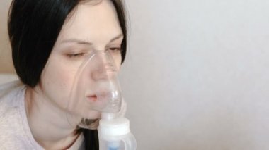 Nebulizatör ve astım tedavisi için kullanın. Closeup kadının yüzü inhaler maskesi teneffüs edilmesi. Önden Görünüm.