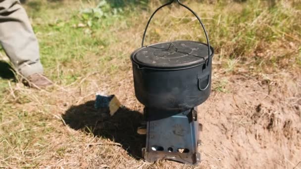 Pot on a metal camp furnace stove on woods outdoors. Close-up. — Stock Video