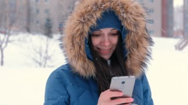 Cep telefonu üzerinde tipik bir haber, kameraya bakıyor ve gülümseyen genç güzel kadın.