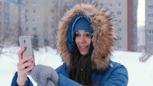 Ung vacker kvinna talar på video på mobiltelefonen i vinter. Face närbild. — Stockvideo