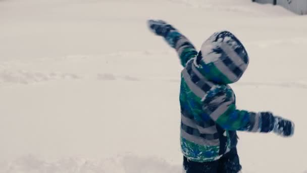 Menino joga neve e brinca com neve . — Vídeo de Stock