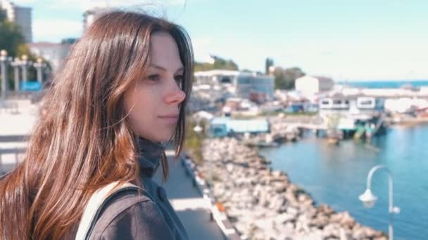 Mujer morena joven mirando el mar en otoño — Vídeos de Stock