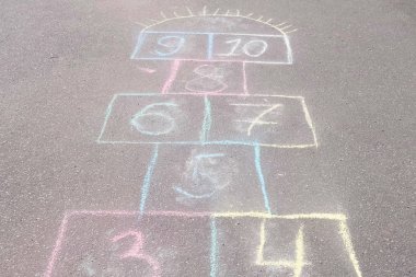 Park asfalt üzerinde seksek oyunu. Renkli mangası ile boyalı.