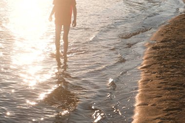 Kırmızı tişört tanınmaz çocukta nehir su üzerinde yürüyor.