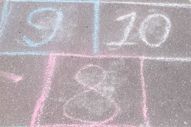 Park asfalt üzerinde seksek oyunu. Renkli mangası ile boyalı.