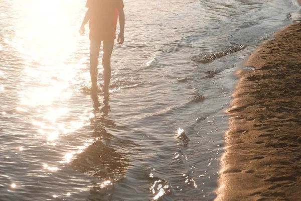 Kırmızı tişört tanınmaz çocukta nehir su üzerinde yürüyor.