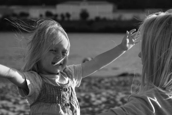아름 다운 금발 엄마와 딸 해질녘 해변에서 껴 안고. — 스톡 사진