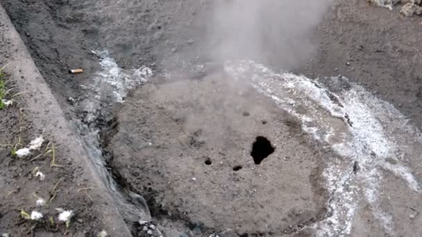 La vapeur provient de la couverture d'égout sanitaire dans la neige sur le bord de la route. Vue de dessus. Gros plan . — Video