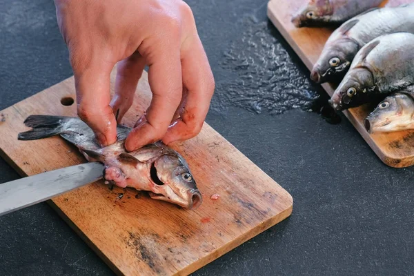 Man strippen van een karper vis. Koken vis. Close-up van de handen. — Stockfoto