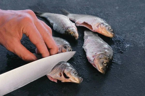 Man maakt bezuinigingen op karper vissen op zwarte lijst. Koken vis. Close-up hand. — Stockfoto