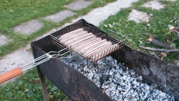 Smažené klobásy na grilovací rošt na uhlí. Boční pohled. — Stock video