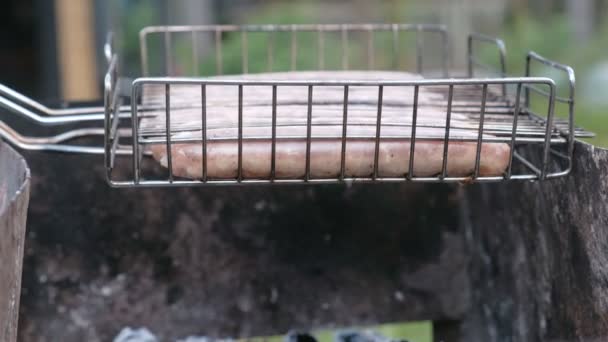 Enchidos no grelhador fritos em carvão vegetal. Vista lateral . — Vídeo de Stock