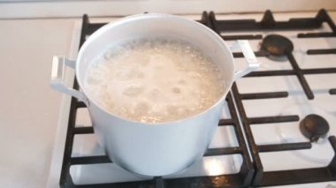 Bir gaz sobası üzerinde bir alüminyum soslu tavada pişmiş pirinç.