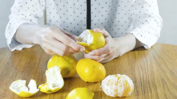 Женщина очищает мандарин вручную. Руки вверх. . — стоковое видео
