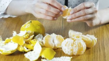 Kadın el ile bir mandalina kabuğu. Eller yakın çekim.