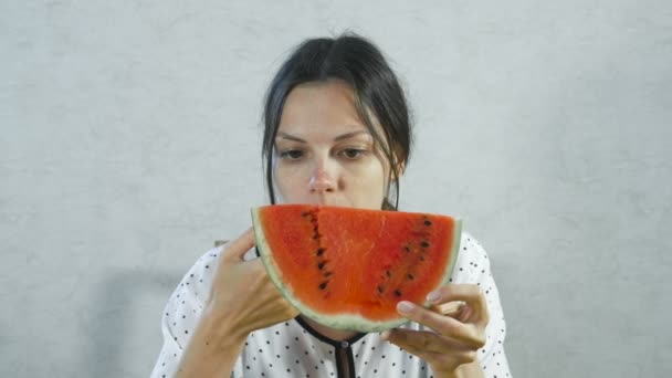 Μελαχρινή γυναίκα τρώει ζουμερό καρπούζι σε λευκό φόντο. — Αρχείο Βίντεο