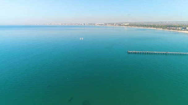 Widok na piaszczystej plaży, morza, nadmorskiej miejscowości i molo z lotu ptaka. — Wideo stockowe
