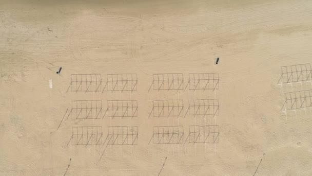 Luftaufnahme über dem Sandstrand mit Liegestühlen außerhalb der Jahreszeiten. — Stockvideo