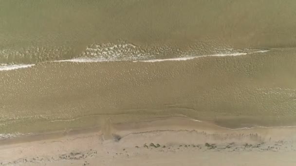 Luftaufnahme des Sandstrandes mit kleinen Wellen. — Stockvideo