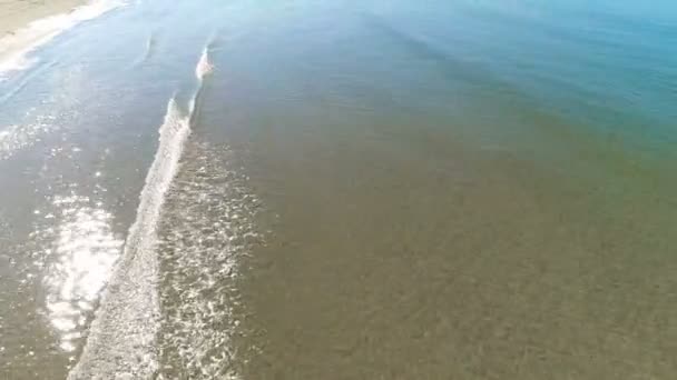 Luchtfoto zijaanzicht van het zandstrand met kleine golven. — Stockvideo