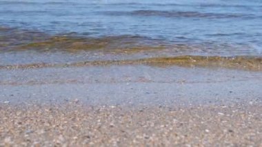 Küçük dalgalar ile kum plaj. Güzel deniz manzarası.
