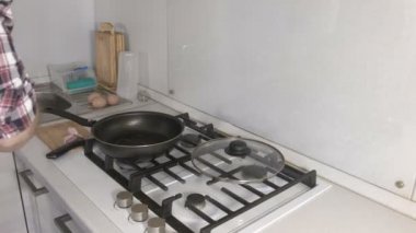 Adam bir tavada sosisli omlet hazırlanıyor. Eller yakın çekim