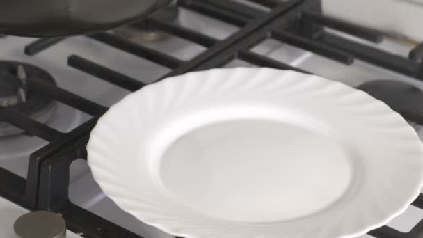 Ponga los huevos revueltos con salchicha de una sartén en la estufa de gas para el plato blanco . — Vídeo de stock