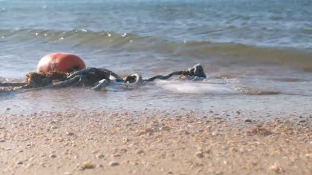 Boyas en las olas en la arena en la costa . — Vídeos de Stock