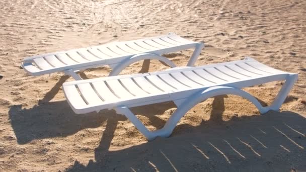 Two sunlongers on the sand beach. — Stock Video
