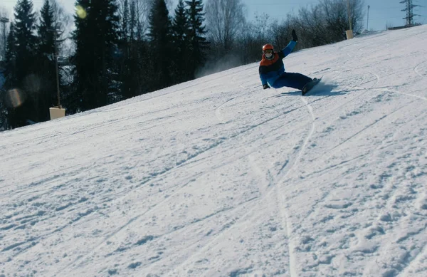 L'homme glisse sur un snowboard et skie depuis la descente de neige . — Photo