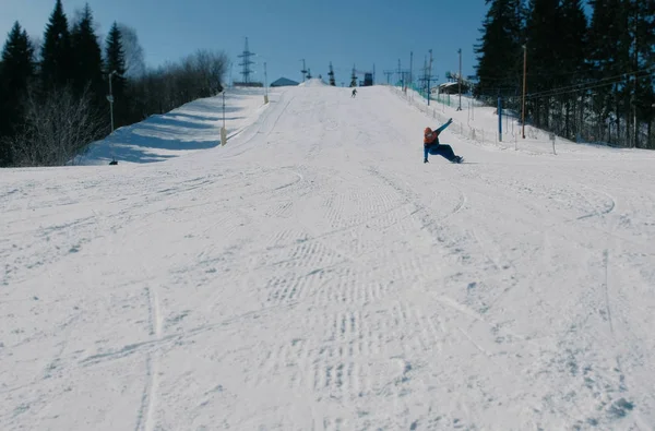 El hombre se desliza en una tabla de snowboard y esquiar desde el descenso de nieve . — Foto de Stock