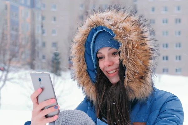 Молодая красивая женщина разговаривает на видео по мобильному телефону зимой. Лицо крупный план . — стоковое фото