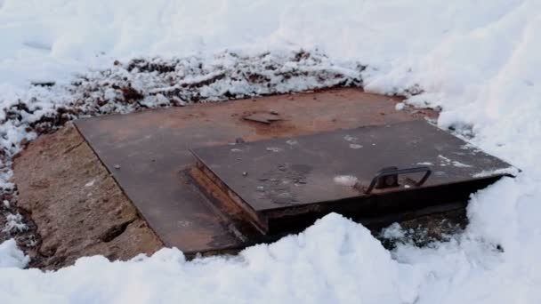 Il vapore è da copertura fognaria sanitaria in neve, neve fusa intorno. Vista da vicino . — Video Stock