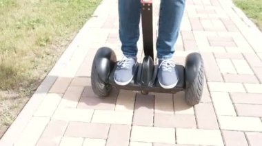 Kişi bacaklarda yol kaldırım üzerinde gyro scooter üzerinde inişli çıkışlı spor ayakkabı.